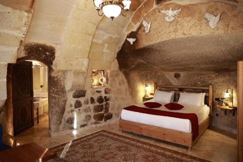 a bedroom with a large bed in a stone room at Peruna Cave in Goreme