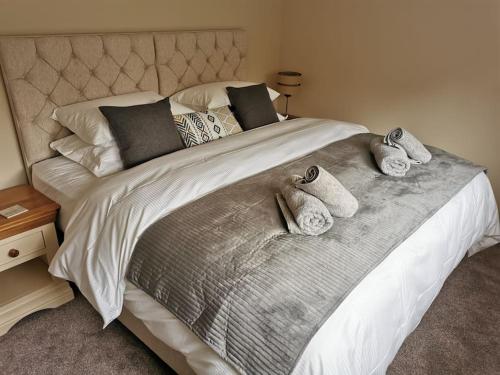 a bedroom with a large bed with towels on it at Woodpeckers - Alresford Essex in Alresford