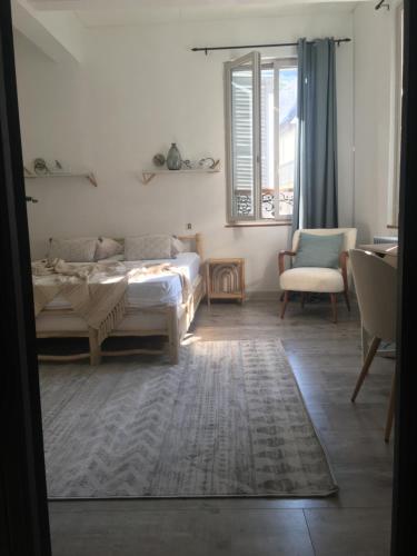 a bedroom with a bed and a couch and a window at «Coeur de vie » logement hyper centre de Bagnères de Bigorre in Bagnères-de-Bigorre