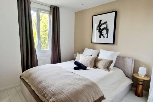 Un dormitorio con una cama con un osito de peluche azul. en Magnifique 3 pièces/terrasse/promenade des Anglais, en Niza