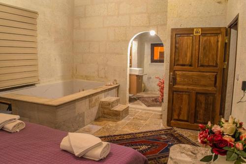 a bathroom with a tub and a bed in a room at ADA FAMILY SUITE in Avanos