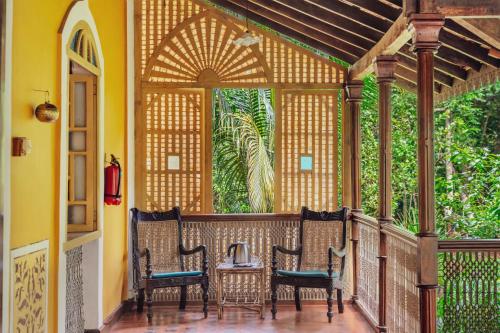 a porch with a table and chairs on it at Villa Sereno by Insignia Villas in Assagao