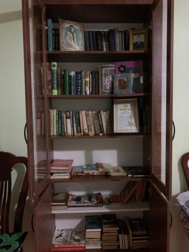 a book shelf filled with books at Guest house В гостях у Лаззат in Türkistan