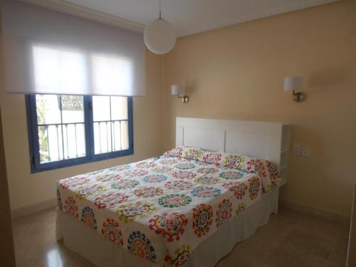 アルムニェーカルにあるGalera Apartmentのベッドルーム1室(花柄のベッドカバー、窓2つ付)