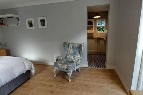 a bedroom with a bed and a chair and a kitchen at The Studio in Kildare