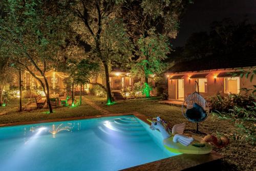 a backyard with a swimming pool at night at Villa Sereno by Insignia Villas in Assagao