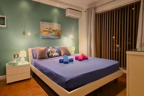 una camera da letto con un grande letto con lenzuola viola e cuscini blu di Unobstructred seaviews, 2BR, Kingbeds, Fully ACd a Marsaskala