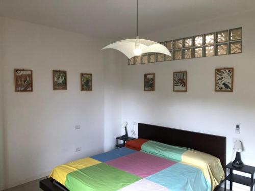 a bedroom with a bed with a colorful blanket at Alloggio Turistico Pratoterra in Bracciano
