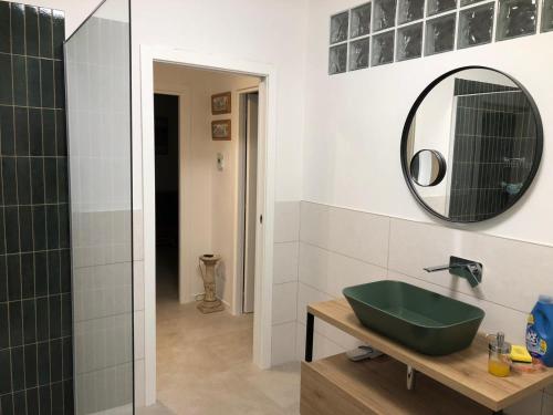 a bathroom with a green sink and a mirror at Alloggio Turistico Pratoterra in Bracciano