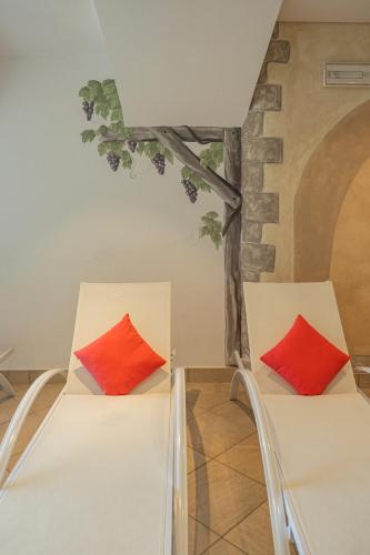 two beds in a room with red pillows at DAS BADL - Smart Retreat AO in Caldaro