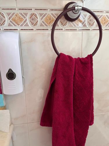 - une serviette rouge suspendue à un porte-serviettes dans la salle de bains dans l'établissement VACATION NEAR THE SEA. (POOL-SHOPS-RESTAURANTS), à Torrevieja
