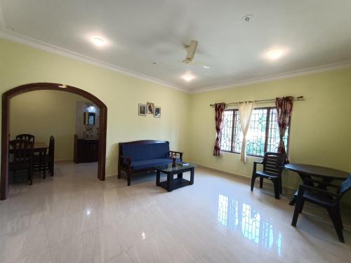 a living room with a blue couch and chairs at Pappa's Guest House in Arambol