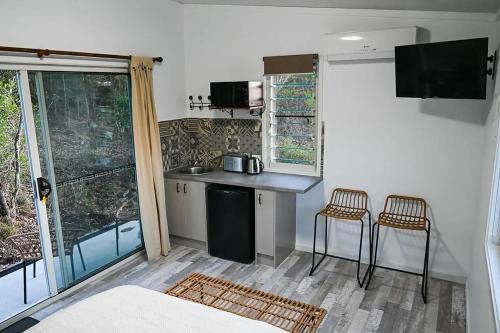 uma cozinha com um balcão e duas cadeiras num quarto em Kiambram Country Cottages em Gowrie Little Plain