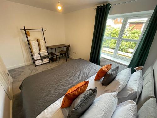 una camera da letto con letto, cuscini e finestra di 3 Bedroom New House with Wi-Fi Sleep 5 By Home Away From Home a Newcastle under Lyme