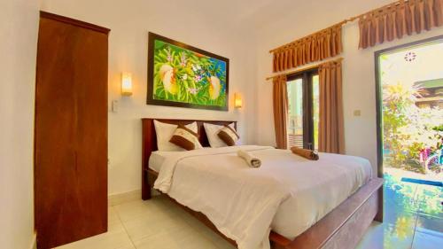 a bedroom with a large bed and a window at Padanta Homestay in Gili Trawangan