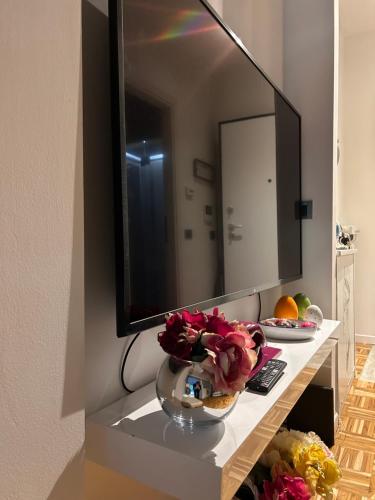 een tafel met een spiegel en een kom bloemen erop bij Appartamento Camilla in Ferrara