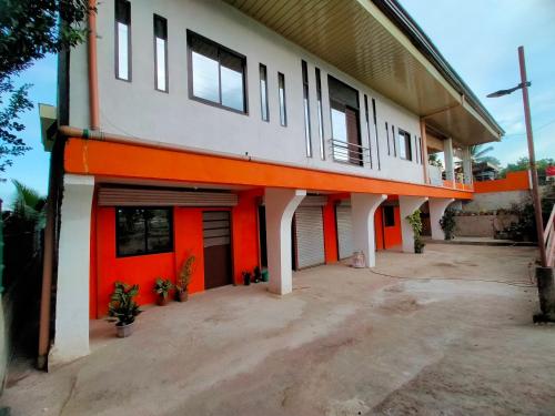 un edificio naranja y blanco con muchas ventanas en AUNORA ROOMS with AC and Kitchen, 