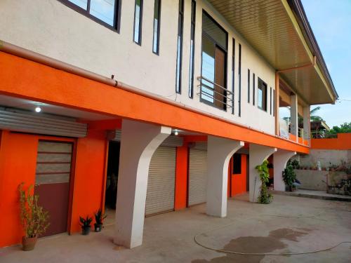 Edificio naranja y blanco con balcón en AUNORA ROOMS with AC and Kitchen, 