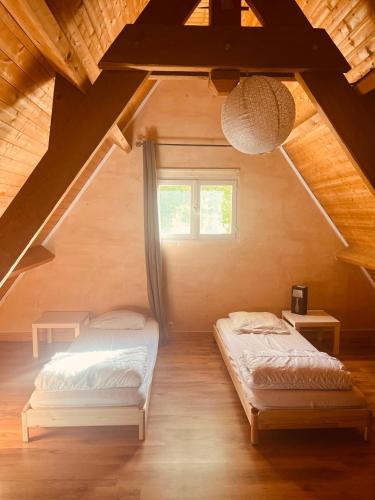 une chambre avec deux lits dans un grenier dans l'établissement Chez Lily, à Domme