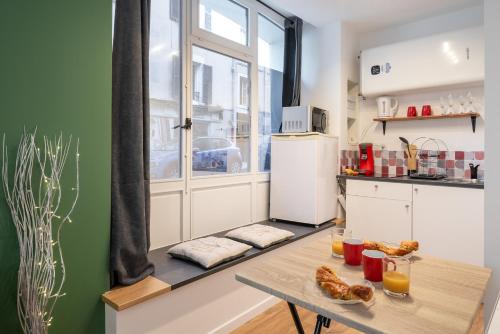 a small kitchen with a table and a window at L'Harmonieux Centre Historique Grenoble in Grenoble