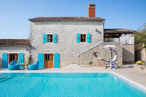 a house with a swimming pool in front of a house at Villa Azzurra in Kanfanar