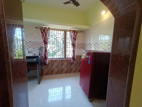 a kitchen with a red refrigerator and a sink at Pappa's Guest House in Arambol