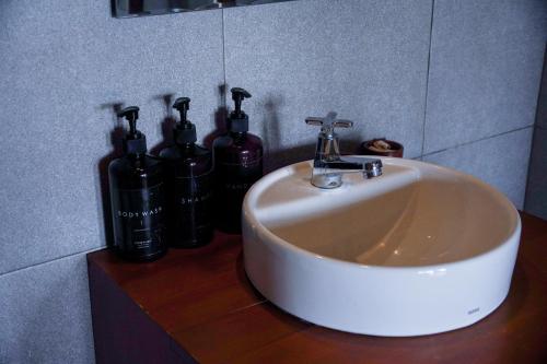 un lavandino in bagno con tre bottiglie di vino su un bancone di Momos Surf Shack a Salul
