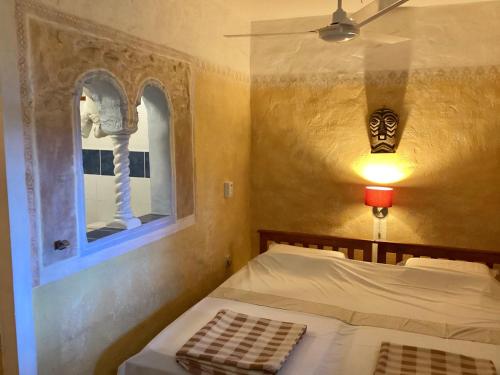 a bedroom with a bed and a window at La Reine Creole in La Gaulette