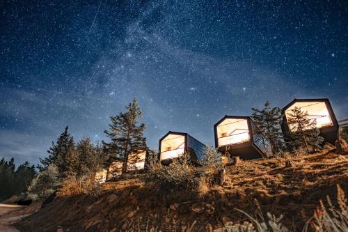een groep glazen huizen op een heuvel 's nachts bij Brandlalm Tinys in Gundisch