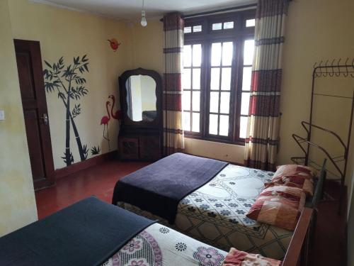a bedroom with two beds and a mirror at Green Villa in Nuwara Eliya
