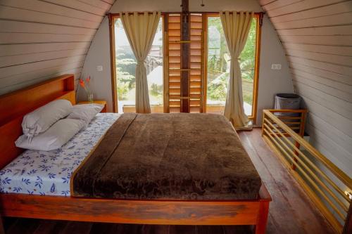 Bett in einem Zimmer mit einem großen Fenster in der Unterkunft Momos Surf Shack in Salul