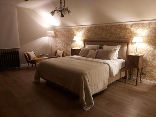 um quarto com uma cama grande e 2 mesas e cadeiras em B&B Asmara em Maasmechelen