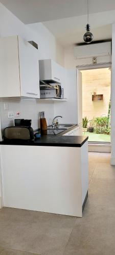 a kitchen with white cabinets and a counter top at Green door Valletta in Valletta