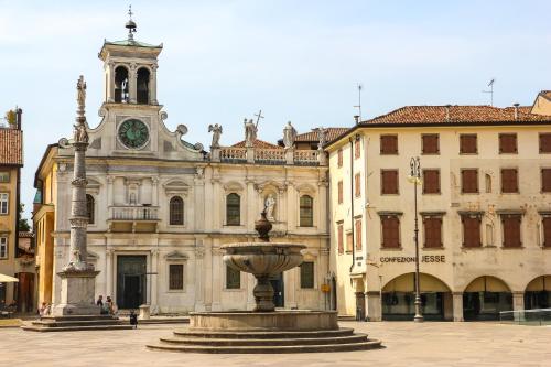 a building with a fountain in front of a building with a clock tower at AVD - La Nuova Casa di Nonna in Udine