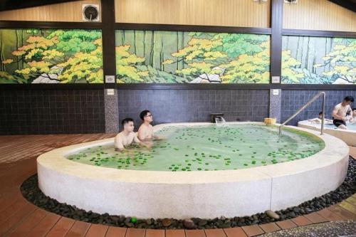 two men in a hot tub with green water at LYNN TIMES THANH THỦY - Khu Nghỉ Dưỡng KHOÁNG NÓNG in Phú Thọ