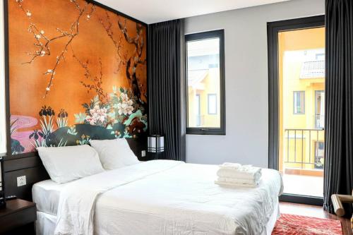 a bedroom with a bed with a large painting on the wall at LYNN TIMES THANH THỦY - Khu Nghỉ Dưỡng KHOÁNG NÓNG in Phú Thọ