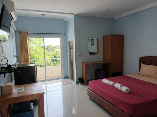 a bedroom with a bed and a television and a window at Center Place Ang Thong 