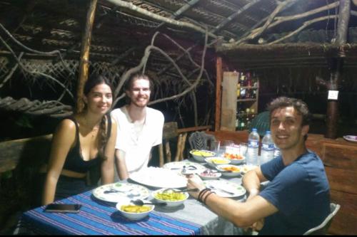 a group of people sitting at a table with food at Relax Nature Villa in Sigiriya