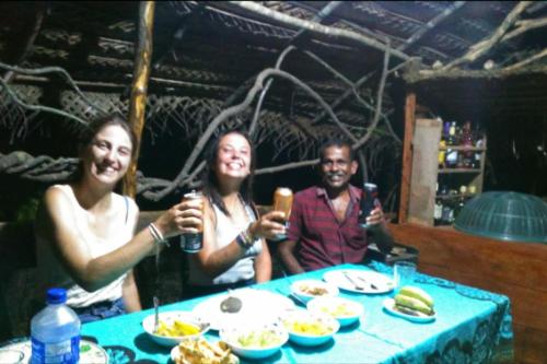 a group of three people sitting at a table with food at Relax Nature Villa in Sigiriya