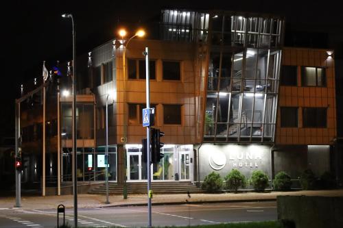 a traffic light in front of a building at night at Luna Self Check-in Hotel Klaipeda in Klaipėda