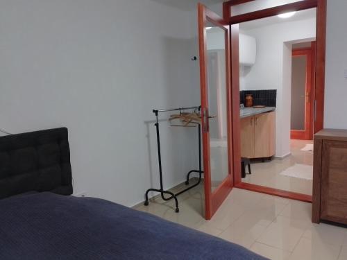 a bedroom with a bed and a mirror and a bathroom at Káli Apartman in Bakonybél