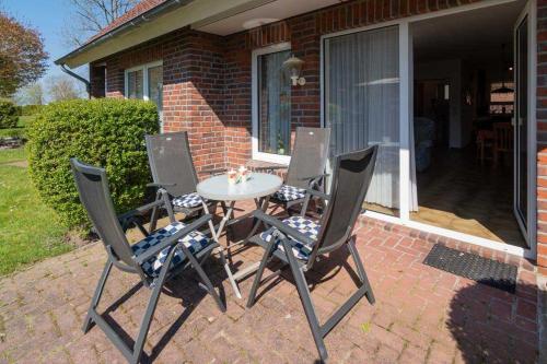 a table and four chairs on a brick patio at Ferienhaus Seewind 11/2 in Werdum