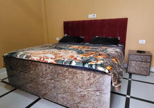 a bedroom with a large bed with a comforter at Panipat Town House panipath in Pānīpat