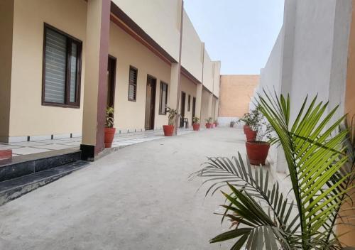 an empty courtyard with potted plants in a building at Panipat Town House panipath in Pānīpat