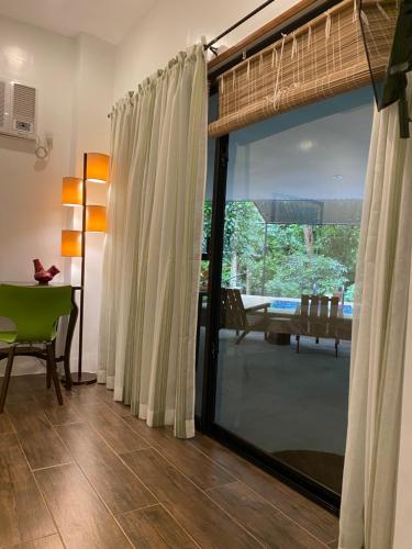 a living room with a sliding glass door to a patio at Balai Benedicere Bed & Breakfast in Bacnotan