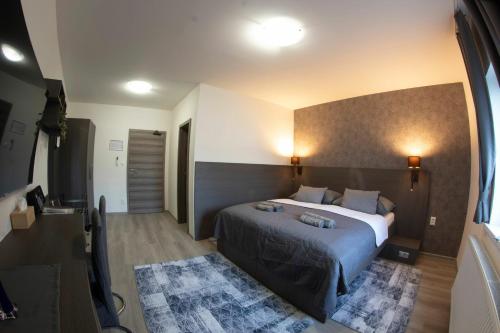 1 dormitorio con 1 cama grande en una habitación en VALLA penzión & reštaurácia en Malacky