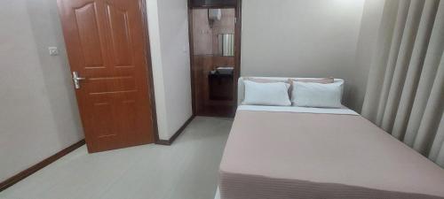 a small room with a bed with two pillows on it at Sami BnB - Apt 03 Makongo after Mlimani City in Dar es Salaam