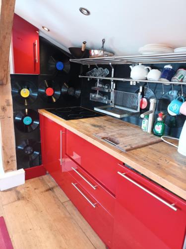 a kitchen with red cabinets and a counter top at Prestwick Oak - Sleeps 10-14 - Group Accommodation for Family or Friends in Haslemere