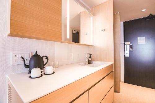 a kitchen with a tea kettle and mugs on a counter at KABIN Taka in Kyoto