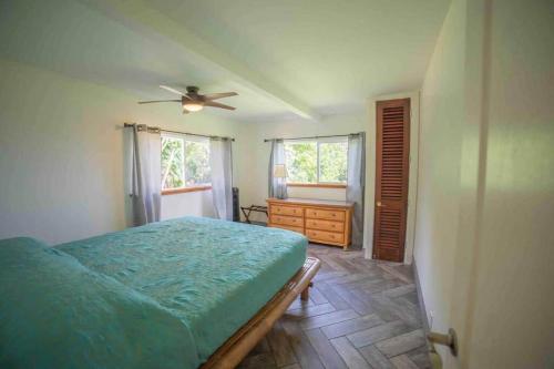 a bedroom with a bed and a ceiling fan at Helehele Hale in Hana